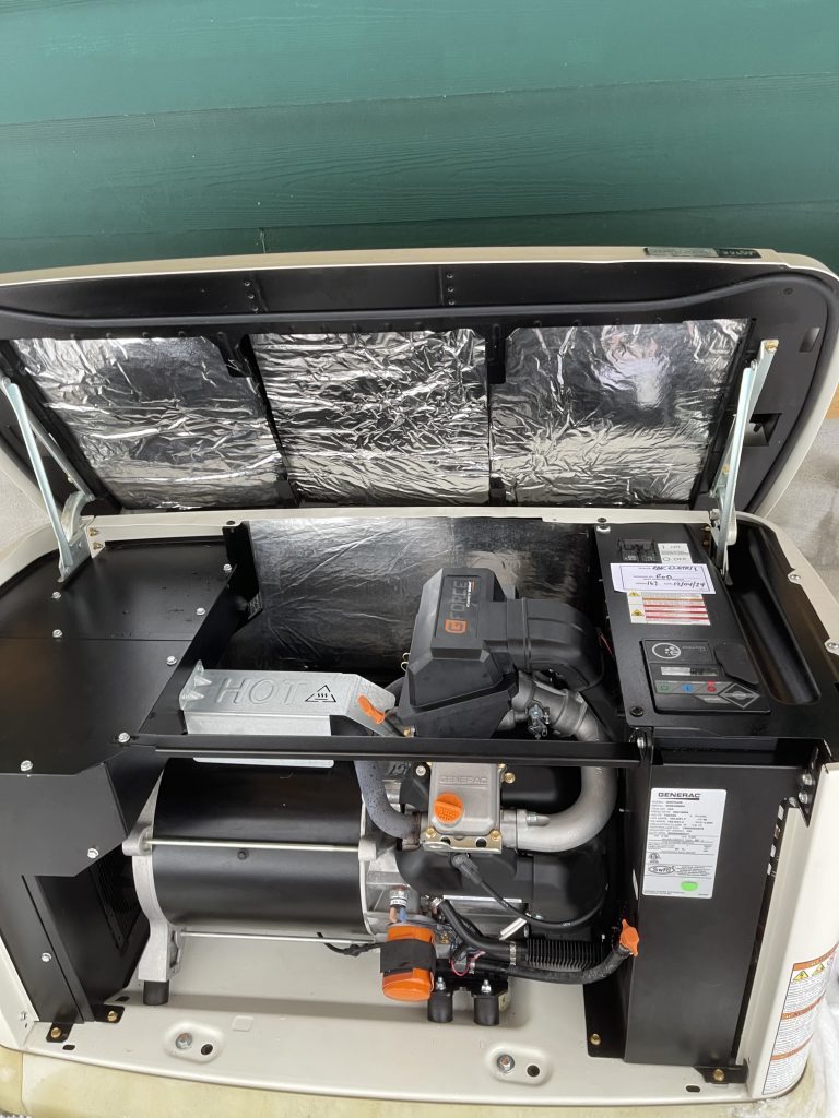 Opened RV generator displaying internal components and model specifications